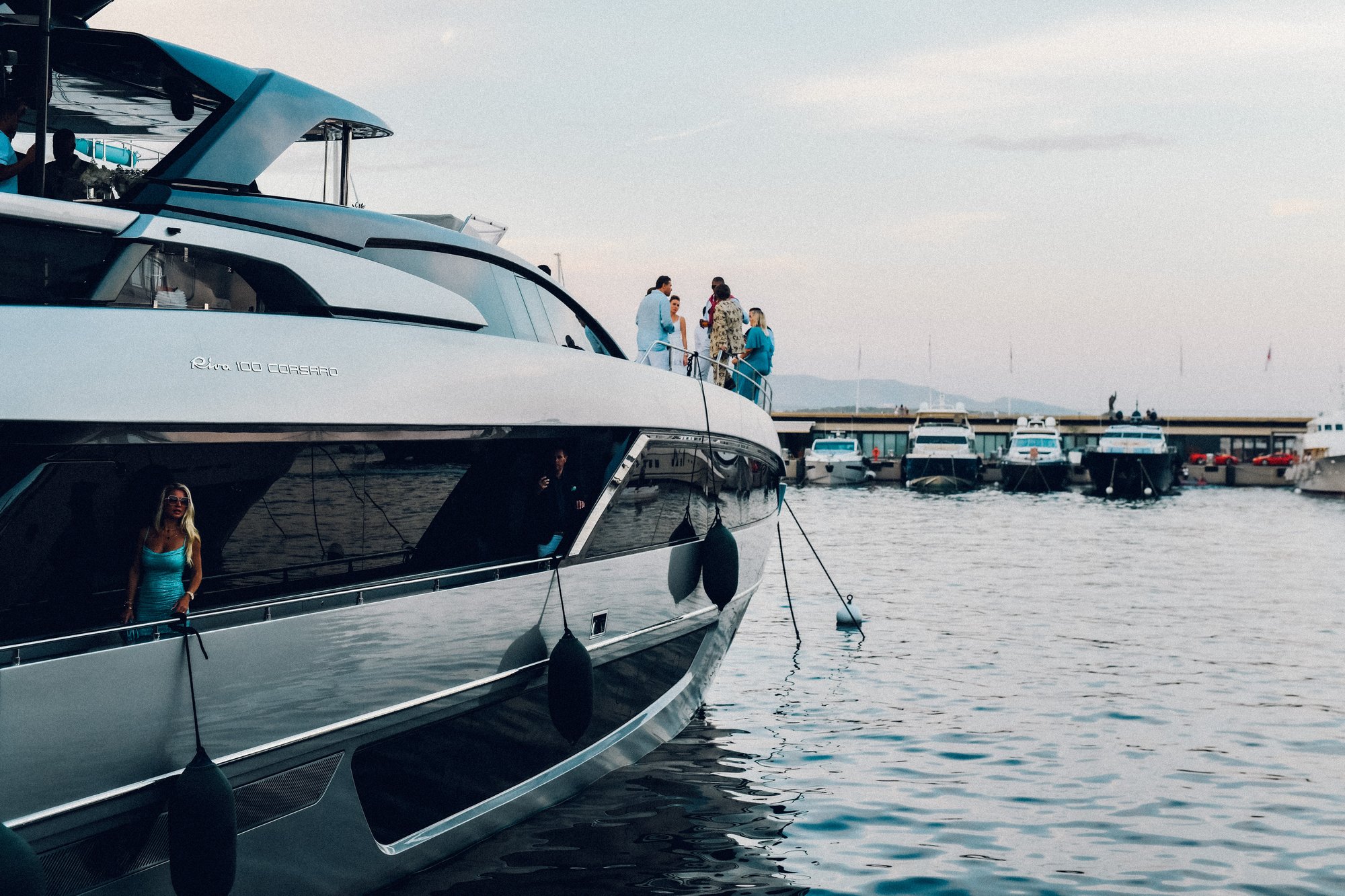 Guests aboard a Riva 100 Corsaro at the Yacht Club de Monaco at dusk